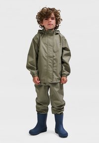 Dziecięcy kombinezon przeciwdeszczowy w oliwkowej zieleni z kapturem. Gładki, wodoodporny materiał; elastyczne mankiety. W komplecie niebieskie gumowe kalosze. Prosty design.