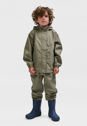 Børne regndragt i olivengrøn med hætte. Glat, vandtæt materiale; elastiske manchetter. Kombineret med blå gummistøvler. Enkel design.