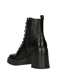 Stivaletto nero realizzato in materiale texturizzato con finitura opaca, caratterizzato da un alto tacco a blocco, zip laterale e design con lacci sulla parte anteriore.