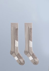 Bruna knästrumpor med vertikalt randmönster, tillverkade av mjukt tyg, med vita detaljer och en solid tå- och häldesign.