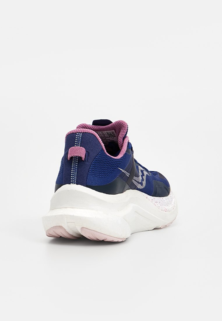 Zapatilla deportiva azul marino con acentos rosas, tejido texturizado y una suela blanca gruesa con un patrón moteado. La vista trasera muestra un collar acolchado.