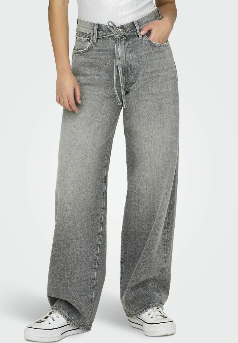 Bredde ben grå jeans laget av denim med innsnørt midje. Har fem lommer, kontraststing og slitt utseende.