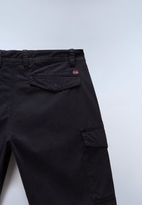 Schwarze Cargo-Hose mit mehreren Taschen, aus Baumwollmaterial gefertigt. Verfügt über ein kleines, gesticktes Flaggen-Detail. Sauberes Design und robuste Nähte.