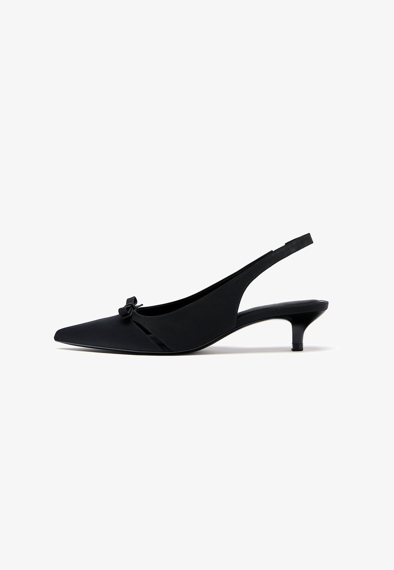 Musta, kärkiosastaan terävä slingback-kengä, jossa on pieni kitten-korko ja koristussolmio edessä, esitetty sivuprofiilissa.