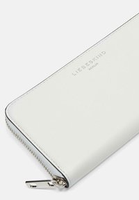 Weißes Lederportemonnaie mit strukturiertem Oberflächen, silbernem Reißverschluss und prägierter Markenlogo "LIEBESKIND BERLIN" in einem schlichten Design.