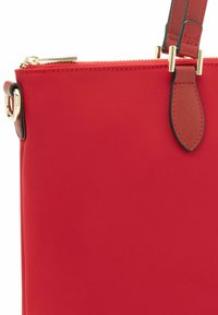 Borsa a mano rossa con una texture liscia, caratterizzata da hardware in tonalità oro, una chiusura superiore a zip e un design strutturato. Le tracolle presentano cuciture decorative.
