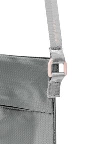 Grau gestrickte Tasche mit einer strukturierten Oberfläche. Verfügt über einen dicken Gurt, eine verstellbare Schnalle in hellrosa und eine vordere Tasche.