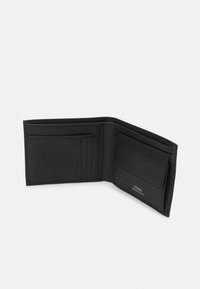Portefeuille en cuir noir avec plusieurs emplacements pour cartes et un compartiment pour billets. Présente une surface texturée et un logo en relief. Vue ouverte.