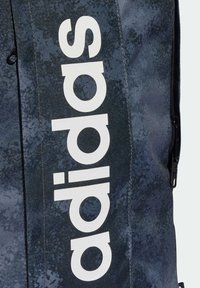 Marineblå sportsryggsekk laget av slitesterk stoff, med et fremtredende hvitt "adidas"-logo og en glidelåslomme på siden.