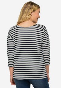 Maglietta a maniche lunghe a righe in blu navy e grigio, con ampia scollatura a barca e tessuto leggero. Vestibilità rilassata con orlo curvo.