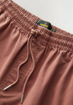 Djelomično ružičaste kratke hlače s elastičnom waistband trakom i vezicom, s metalnim vrhovima i oznakom vidljivom na struku. Mekani pamuk.