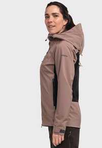 Lightweight softshell jacket in taupe and black, features a hood, zippered side pockets, and textured fabric with a fitted design.