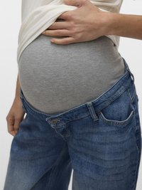 Maternity jeans in a faded blue, featuring a stretchy grey waistband and loose fit, partially unbuttoned, revealing a gray undershirt.