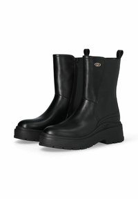 Coppia di stivali in pelle nera a metà polpaccio con suole spesse in gomma, cerniera laterale, linguette per tirare e piccolo dettaglio del logo dorato vicino alla parte superiore.