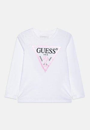 Balta ilgomis rankovėmis marškiniai, pagaminti iš ekologiškos medvilnės, su rožiniu trikampio logotipu su "GUESS" tekstu ir akcentais. Minkšta tekstūra.