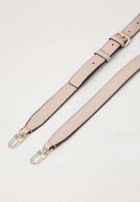 Cinturino in ecopelle beige con hardware color oro, dotato di una texture liscia, lunghezza regolabile e due ganci a scatto per il fissaggio.