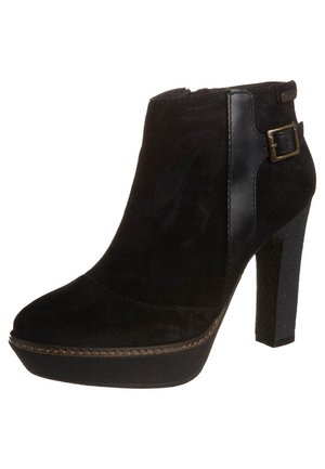 Musta nilkkuri, joka on valmistettu mokasta ja teksturoidusta synteettisestä materiaalista, varustettu korkealla stiletto-korkeudella, alustalla ja koristeellisella soljella.