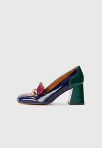 Scarpa con tacco alto brevettata in pelle verniciata blu navy e verde con un fiocco in accento bordeaux e hardware metallici. Tacco a blocco dalla forma quadrata.