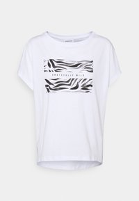 Camiseta blanca de algodón, con mangas cortas y dobladillo redondeado. Presenta un estampado de raya de cebra en blanco y negro con el texto "GRATEFULLY WILD."
