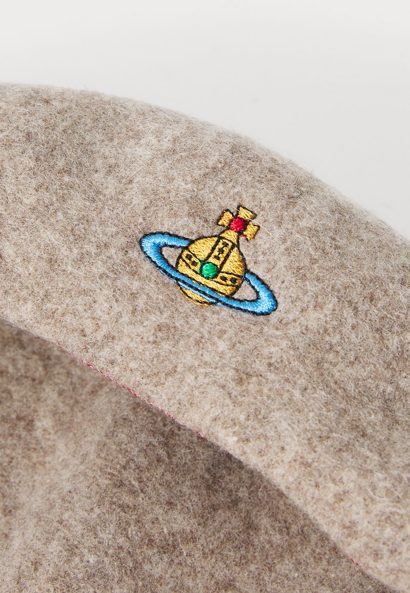 Beige Filzkappe mit einem bunten gestickten Motiv eines Raumfahrzeugs mit Ringen, akzentuiert mit roten und grünen Details.