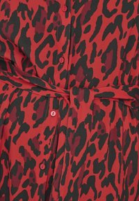 Rood en zwart dierenprint jurk met knopen, een strik taille en een gladde textuur. Het ontwerp heeft een ceintuursilhouette.