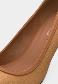 Κοντινό πλάνο σε ταμπά μπαλαρίνα με υφή, με λείο δερμάτινο περίγραμμα και επενδεδυμένο πάτο.