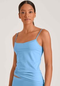 Lichtblauwe tanktop met dunne bandjes, een vierkante halslijn en een zachte, rekbare stof. Beschikt over een aansluitend ontwerp en geplooide textuur bij de taille.