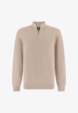 Beige gebreide trui met structuur, voorzien van een geribbelde V-hals, manchetten en zoom, met een klein zwart merklipje binnenin de kraag.