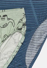 Drei Paare Kinderunterwäsche: ein grünes mit schwarzem Monsterdruck, ein blau gestreiftes und ein grau gestreiftes mit weißen Linien.