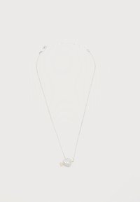 Ασημένιο κολιέ με αλυσίδα και μενταγιόν σε σχήμα καρδιάς, διακοσμημένο με μικρά κρυστάλλινα στοιχεία και μια μικρή χρυσή λεπτομέρεια σε σχήμα βέλους.