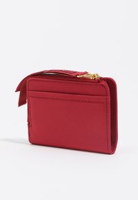 Raudonas stačiakampis piniginė su išorine kišenėle, auksinėmis užtrauktuko detalėmis ir audinio traukimo juostele ant balto fono.