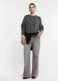 Grau gestrickter Pullover mit einem schwarzen Bindeband auf Taillenhöhe, kombiniert mit hellgrauen, ausgestellt geschnittenen Jeans. Einfaches Design, weiche Textur und lässige Passform.