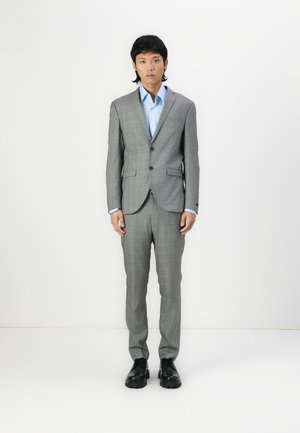 Gray plaid suit with a fitted design. Light blue shirt underneath, black shoes. Smooth fabric, single-button jacket, and tailored trousers.