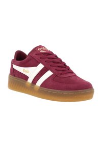 Sneaker in suede bordeaux con strisce in pelle bianca, chiusura con lacci, colletto imbottito e suola in gomma trasparente. Accento con logo dorato sulla linguetta.