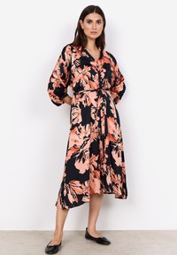Blumen Kleid mit schwarzem Grund, großen rosa und pfirsichfarbenen Blumen, Knopfleiste und einem Bindegürtel. Lange Ärmel mit gerafften Manschetten.