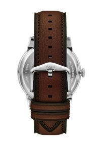 Cinturino in pelle marrone con bordi scuri, dotato di fori rettangolari, fibbia in metallo argentato e logo "FOSSIL" impresso. Cassa in acciaio inossidabile visibile.