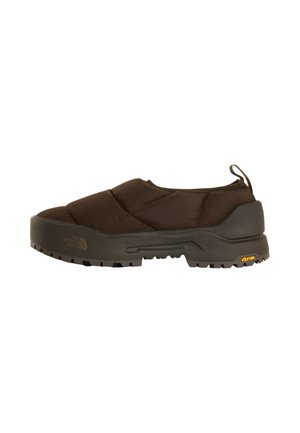 Scarpa marrone slip-on isolata con suola spessa e robusta e linguetta sul tallone, marchiata con i loghi The North Face e Vibram.