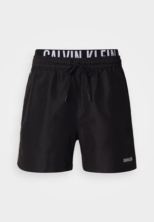 Costume da bagno nero con vita elastica, coulisse regolabile e tasche laterali. Presenta il logo bianco "CALVIN KLEIN" sulla vita e sulla gamba.