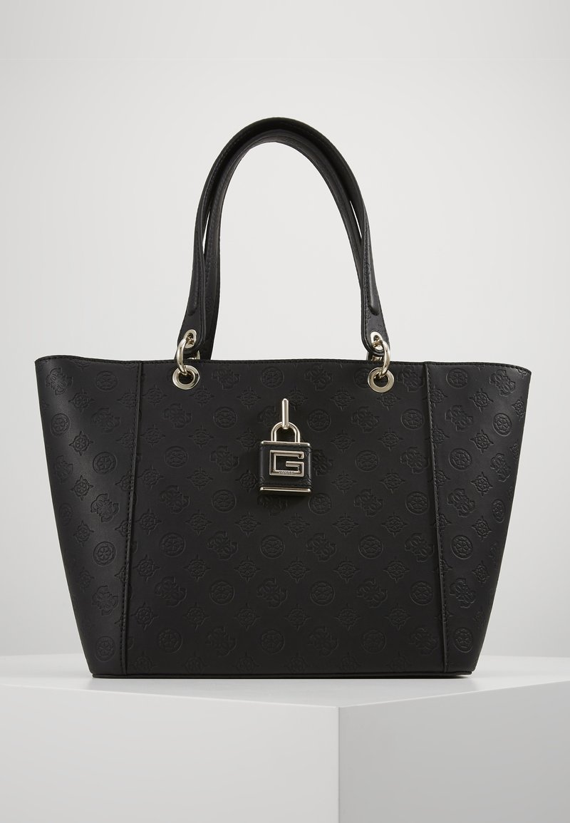 Schwarze Tragetasche aus strukturiertem synthetischem Material. Verfügt über Metallbeschläge in Goldtönen, ein geprägtes Logo-Muster und doppelte Tragegriffe. Quadratische Form.