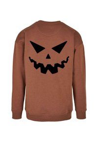 Pruun kapuutsiga särg, millel on pikad varrukad ja mille seljal on suur must jack-o'-lantern graafika, mida rõhutavad sakilised ääred ja teravad nurgad.