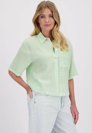 Licht muntgroen, kortemouw overhemd met knopen heeft een zak, een relaxte pasvorm en een gemêleerde stof. Gecombineerd met lichte denim jeans.
