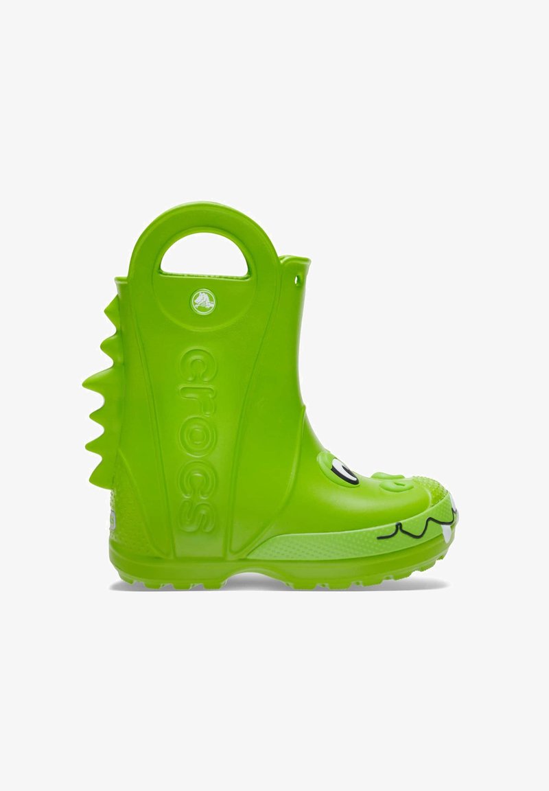 Botas de goma verdes para niños con una cara de dibujos animados, picos texturizados en la parte trasera y un asa redonda para facilitar su uso.