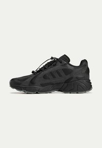 Black athletic sneakers with a textured upper, featuring three side stripes, a cushioned sole, and a secure lace system for fit adjustment.