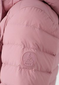 Sezione con giacca imbottita rosa caratterizzata da una texture liscia, design trapuntato e un'etichetta con il logo JOTT che presenta una figura cartone animato in scooter.