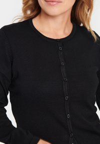Schwarzer gerippter Cardigan mit Knopfleiste, runder Halslinie und langen Ärmeln. Der Stoff hat eine glatte Textur und einen feinen Glanz.
