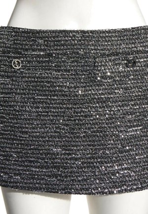 Zwarte gestructureerde minirok met horizontale ribbels en kleine glanzende pailletten, met twee ronde metalen knopen vlakbij de tailleband.