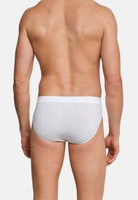 Weiße Baumwollunterhose mit geripptem Struktur und einem weißen elastischen Bund, die ein figurbetontes Design und einen schlichten Stil aus der Rückansicht zeigt.