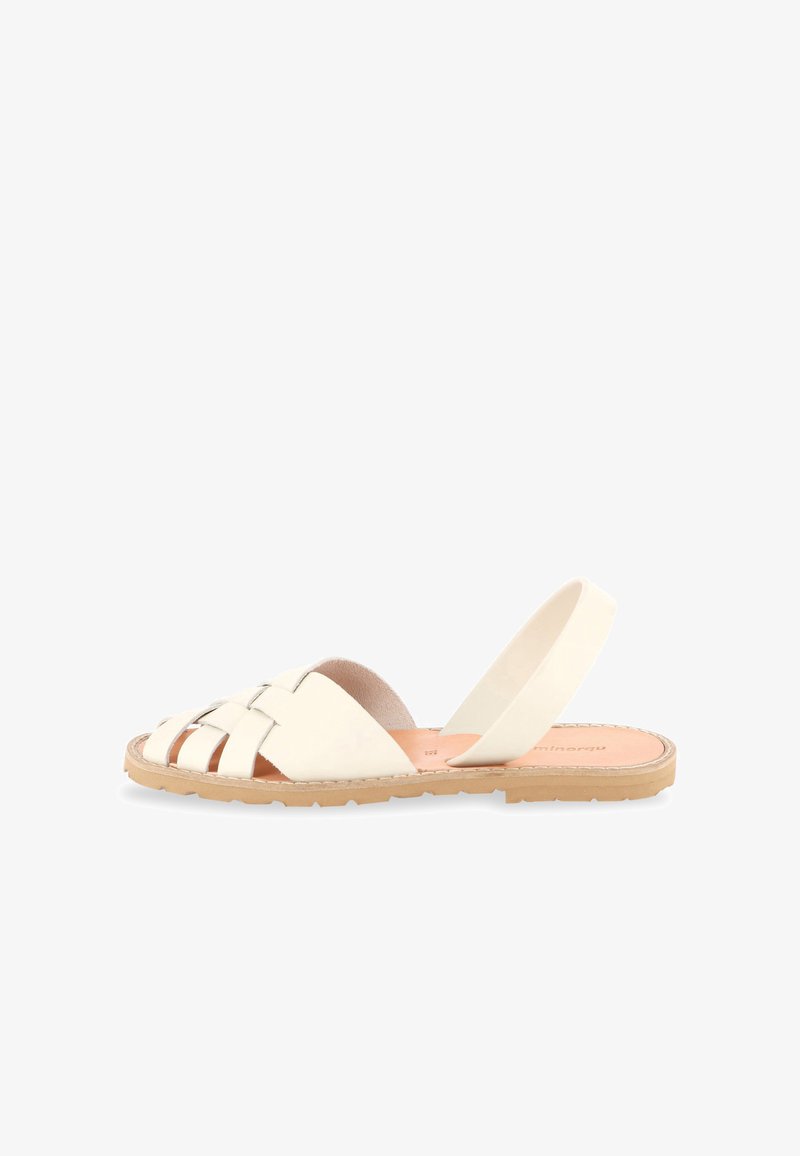 Sandale plate avec tige en cuir crème tressé, bout ouvert et semelle en caoutchouc marron clair, équipée d'une bride élastique au talon pour un maintien sécurisé.