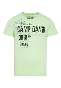 Camiseta de algodón verde claro con gran texto en negro "CAMP DAVID" y varias frases en blanco, de manga corta y con diseño de cuello redondo.