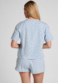 Lichtblauw loungewear-set van zachte stof, met zwarte polkadots. Korte mouwen top en korte broek, met een ontspannen pasvorm.